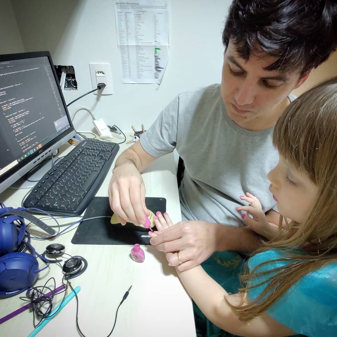A picture of me, painting my daughter's nails in front of a computer